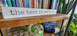 picture oh a bookshelf with a sign that says the best is yet to come